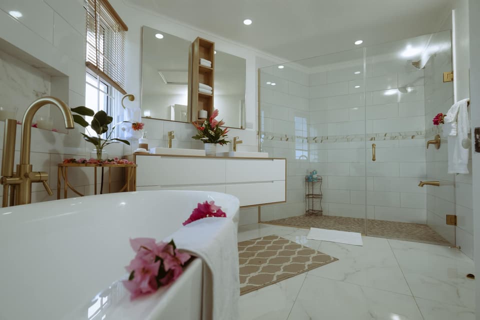The soaking tub in the primary bathroom at Bay Vista Villa, with flowers floating in the water
