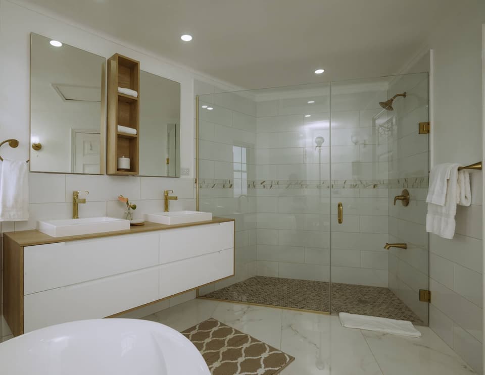Double vessel sinks on a floating vanity and a glass shower in the primary bathroom at Bay Vista Villa