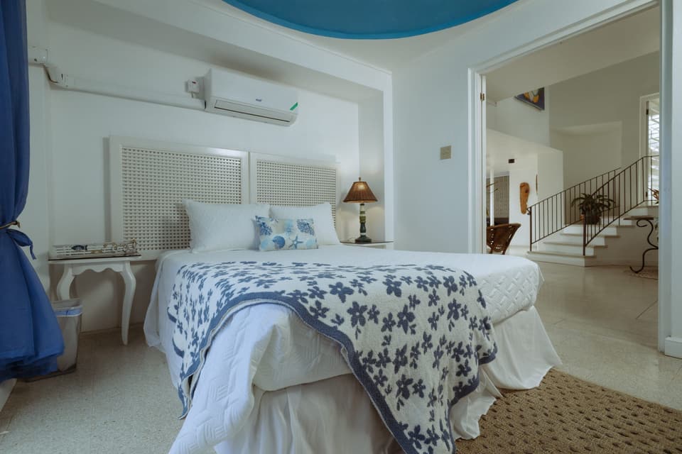 The Forget-Me-Not Cozy Room at Bay Vista Villa, its bed dressed in blue-and-white linen