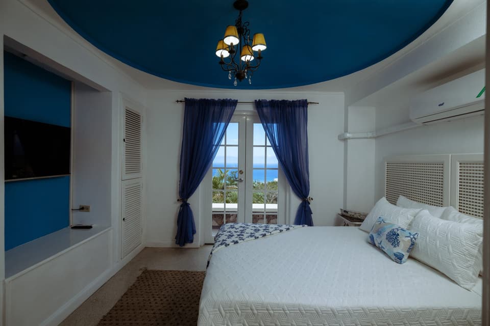 Blue curtains and a chandelier in the Forget-Me-Not Cozy Room at Bay Vista Villa