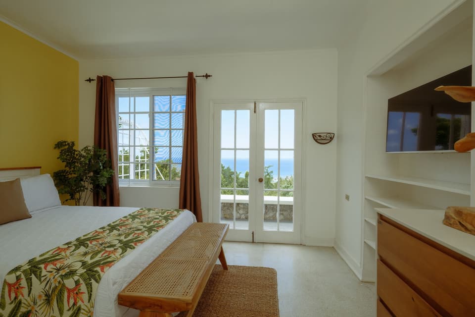 French doors opening from the Yellow Bird Room at Bay Vista Villa onto a small balcony
