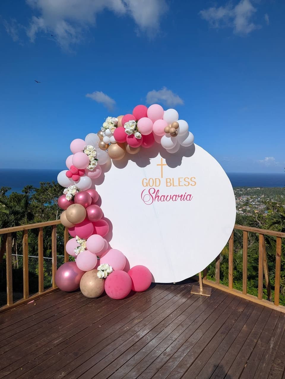 A pink and gold balloon arch on the deck at Bay Vista Villa for a birthday celebration