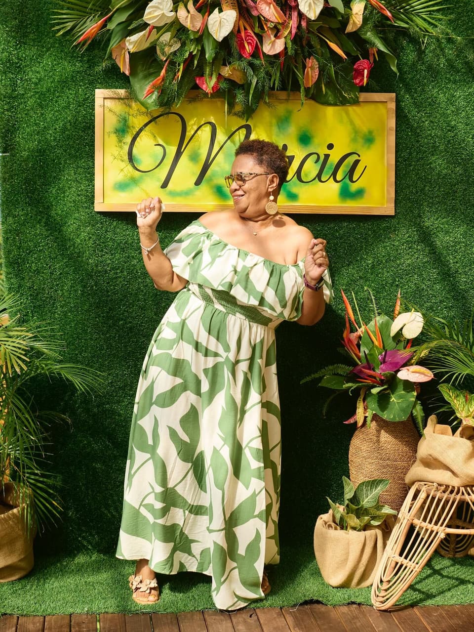 A birthday guest in front of a greenery wall with her name at Bay Vista Villa
