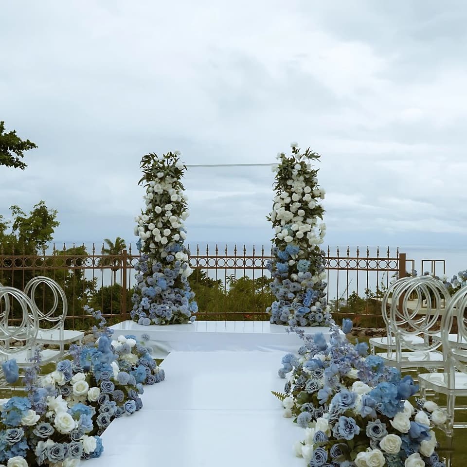 A white aisle lined with blue and white flowers on the lawn at Bay Vista Villa, overlooking the bay