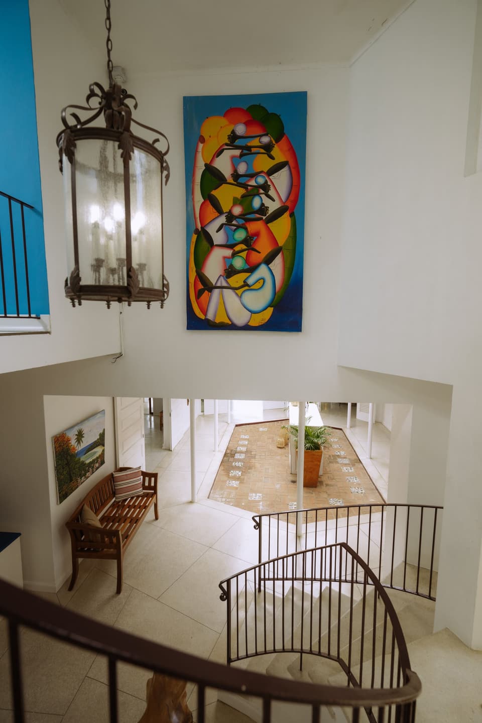 The entrance hall of Bay Vista Villa seen from the landing, with Jamaican artwork on the walls