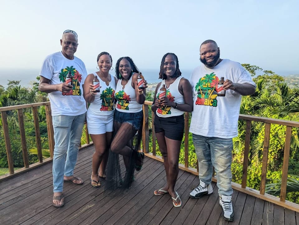 Guests raising Red Stripe beers on the deck at Bay Vista Villa on arrival