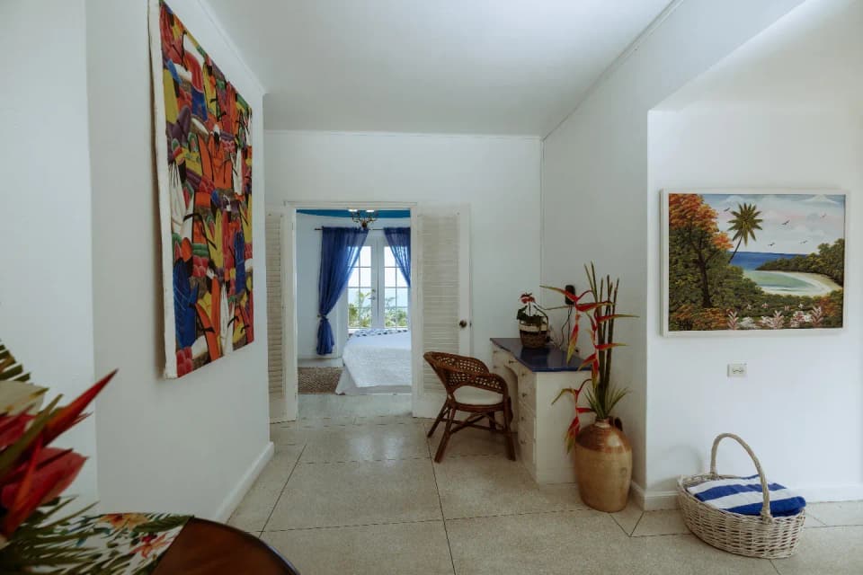 A hallway at Bay Vista Villa hung with Jamaican art, leading to the bedrooms