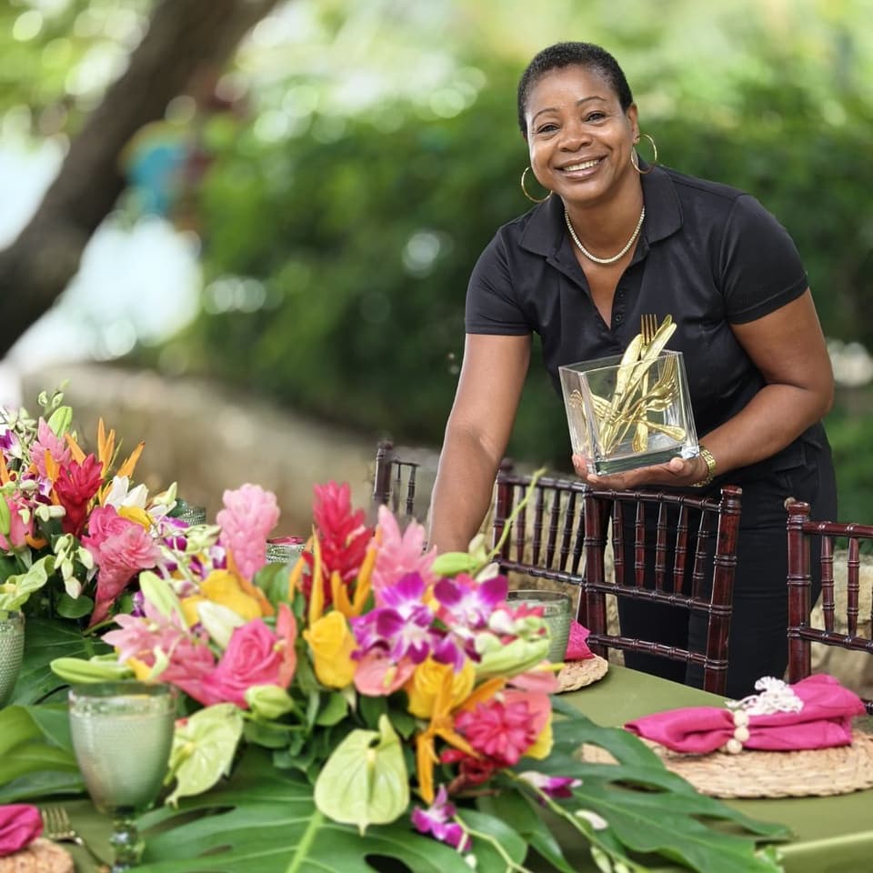 Michelle arranging tropical flowers on a table at Bay Vista Villa