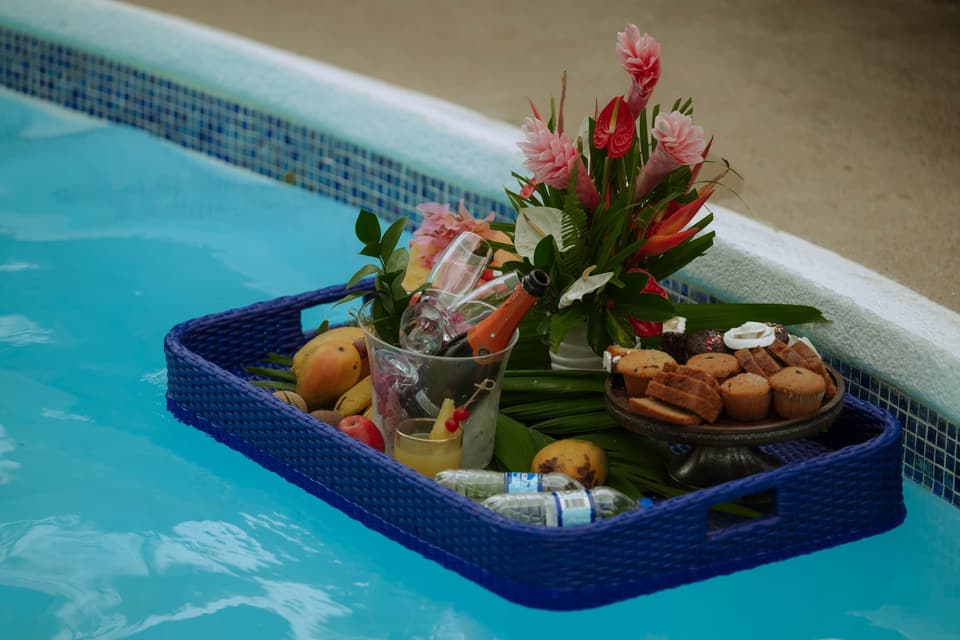 A floating breakfast tray with tropical flowers and fruit in the pool at Bay Vista Villa