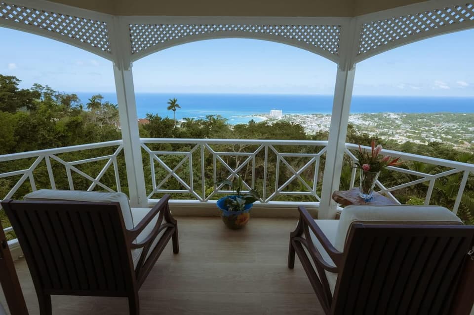 Two chairs on the balcony at Bay Vista Villa with the bay of Ocho Rios below