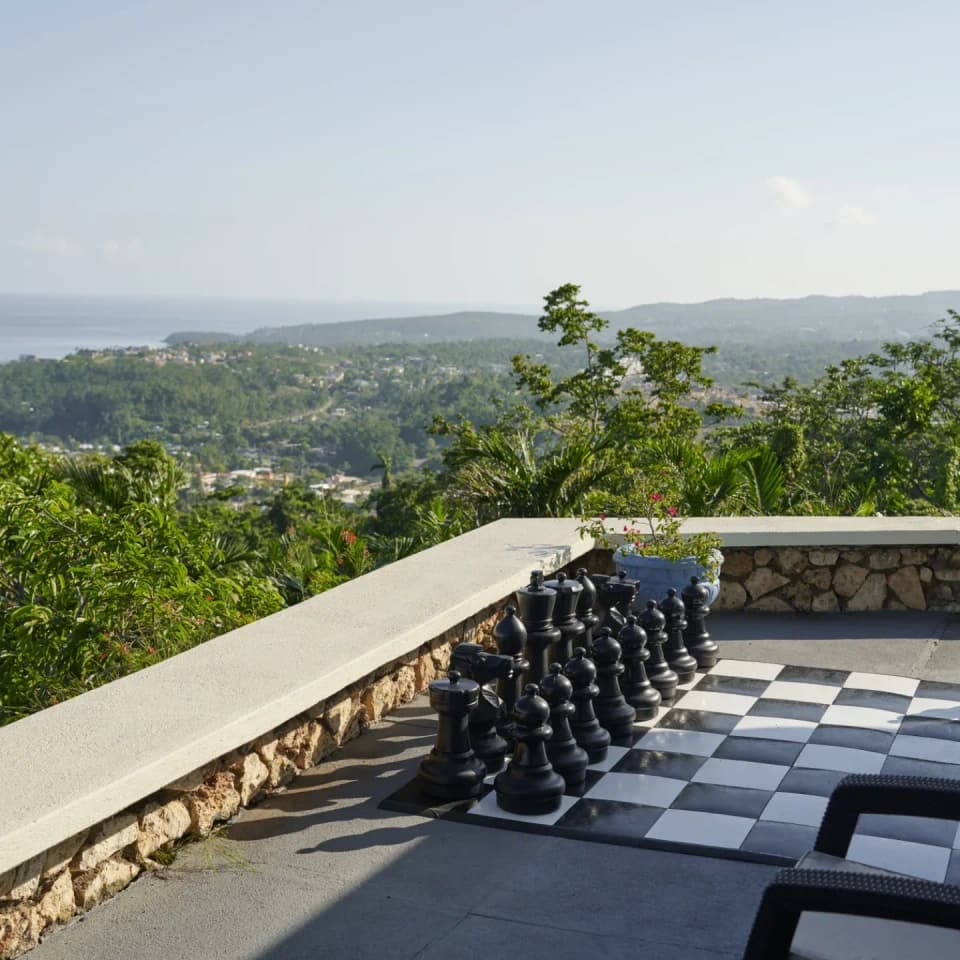The giant outdoor chess set on the stone terrace at Bay Vista Villa overlooking the hills and sea