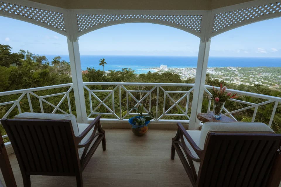 The white latticed balcony of Bay Vista Villa framing the sea view over Ocho Rios